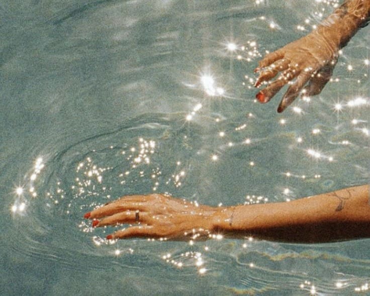 Hands moving through water, evoking calm, regulation, and aligned choices in business.